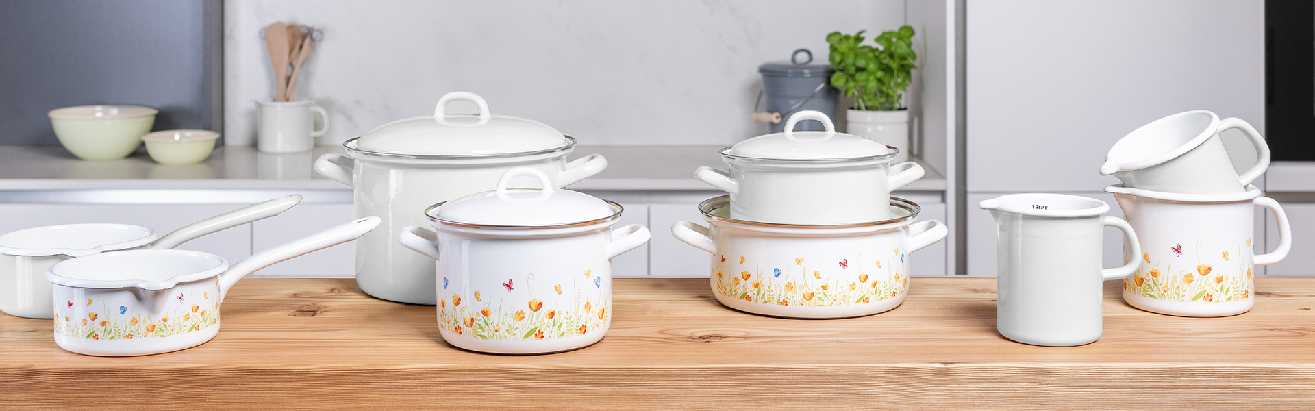Weißes Emaille-Kochgeschirr mit Blumen und Schmetterlingen